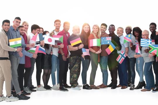 Eine Gruppe multinationaler Menschen hält die Flaggen ihrer Heimatländer und freut sich, dass mit Engity für jede Region und Sprache eine eigene Anpassung möglich ist.