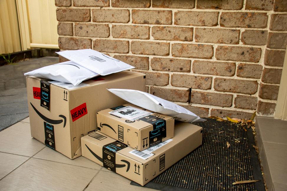 Unwanted Amazon packages left behind in front of door of consumers as part of brushing scam.