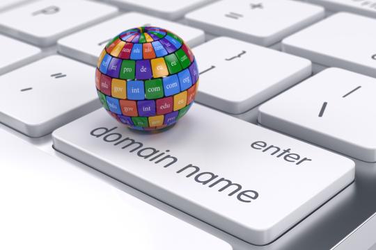 Vector image illustrating a keyboard with domain name written on it and a colorful ball with many country code endings sitting on it.