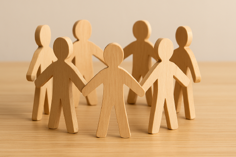 With Engity, you get an experienced team Seven small wooden figures stand on a table and form a circle.